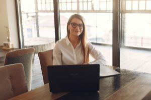 woman-in-white-polo-shirt-sitting-in-front-of-a-black-laptop-3874032