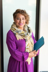 woman-smiling-and-holding-teal-book-1181424